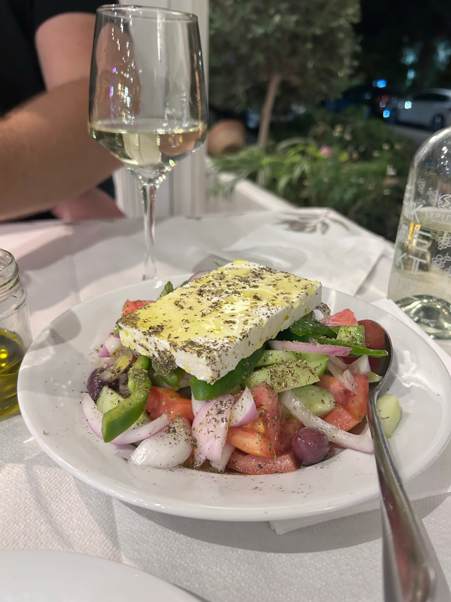 A classic Greek salad with feta, tomatoes, cucumbers and onions, served with white wine
